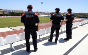 Pla general de tres agents de la unitat ARRO dels Mossos d'Esquadra, d'esquenes, a l'estadi d'atletisme de l'Anella Mediterrània de Tarragona. ACN