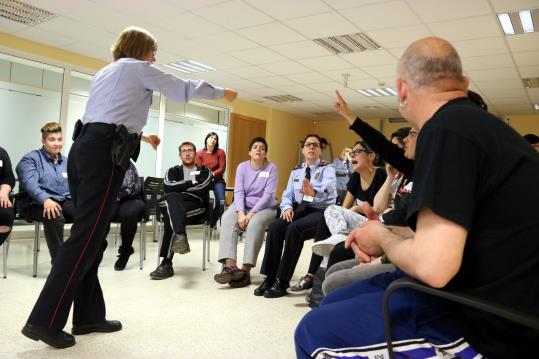 Pla general del grup d'un grup de persones amb discapacitat intel·lectual en un taller amb els Mossos d'Esquadra a Malgrat de Mar. ACN