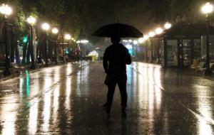 Pla general d'un home caminant amb paraigües sota la pluja a la Rambla de Tarragona. ACN