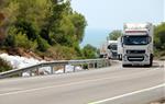 Pla general d'uns camions passant pel costat de les deixalles de plàstic que han quedat després de l'accident mortal en aquest punt de l'N-340. ACN