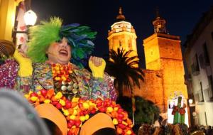 Pla mig del Rei Carnestoltes de Sitges en un últim suspir abans de ser traslladat per a l'enterrament, amb l'església de la Punta al fons. ACN