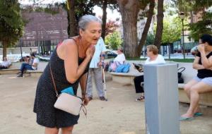 Pla mig d'una dona refrescant-se en una font de Figueres davant l'onada de calor aquest 2 d'agost de 2018. ACN