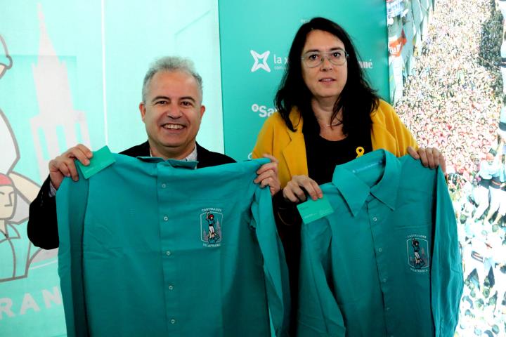 Pla mitjà de la dona de Raül Romeva, Diana Riba, i del gestor cultural Jordi Bertran, mostrant les camises i els carnets com a socis honorífics. ACN