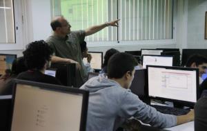 Pla mitjà d'una aula d'informàtica de l'institut Baix Camp de Reus, amb un professor entre els alumnes. ACN