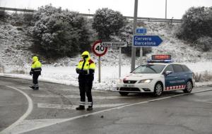 Pla obert on es pot veure una patrulla de Mossos d'Esquadra restringint l'accés de camions a l'A-2 per la nevada, a Tàrrega. ACN