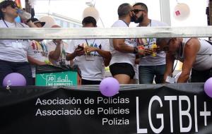 Pla sencer de dos home fent-se un petó dalt la carrossa en defensa dels drets dels policies LGTBI. ACN