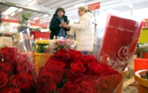 Primer pla de rams de roses amb una majorista venent productes a una clienta en el Mercat de Flor i Planta Ornamental de Catalunya. ACN