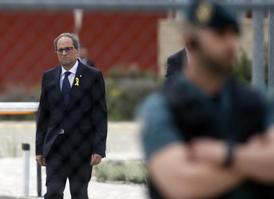 Quim Torra, al fons de la imatge i lluint un llaç groc, en un dels accessos de la presó d'Estremera. ACN