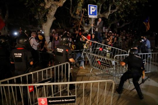 Tensió a les portes del Parlament entre els Mossos i alguns manifestants, empentant les tanques de protecció per accedir a l'edifici. ACN