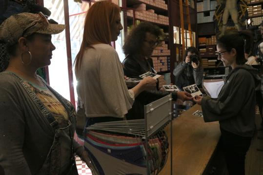 Tres dones transsexuals parlen amb la dependenta d'una merceria a qui reparteixen postals de la campanya de conscienciació. ACN
