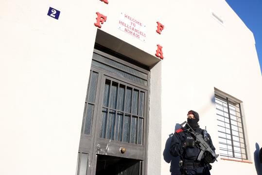 Un agent dels Mossos d'Esquadra a la porta de la seu de 'Hells Angels', a Sabadell, mentre transcorre l'operatiu policial. Mossos d'Esquadra