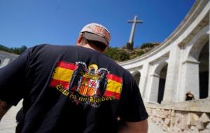 Un home amb una bandera franquista al Valle de los Caídos. ACN / Reuters