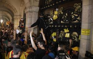 Un manifestant enfilat a la porta del Parlament de Catalunya després de la manifestació per commemorar el primer aniversari de l'1-O. ACN