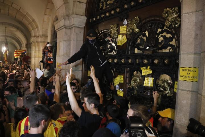 Un manifestant enfilat a la porta del Parlament de Catalunya després de la manifestació per commemorar el primer aniversari de l'1-O. ACN