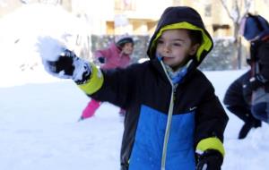 Un nen juga amb la neu al pati de l'escola Guillem de Mont-rodon de Vic, aquest dimarts al matí. ACN