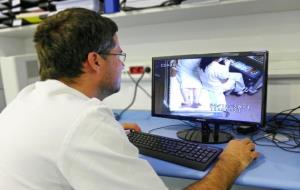 Un treballador de la Unitat d'Ictus de l'Hospital Universitari Vall d’Hebron controla un pacient ubicat al llit que té un sistema de monitoratge . Hos