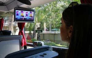 Una noia a l'interior d'un autocar mira el vídeo que donarà consells de seguretat als passatgers a l'inici del trajecte. ACN