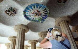 Una turista fotografia els medallons restaurats de la sala Hipòstila del Parc Güell. ACN / Bataller J.