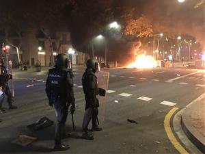 Agents de la Policia Nacional aturats a uns metres d'una barricada en flames a Barcelona el 15 d'octubre del 2019. ACN