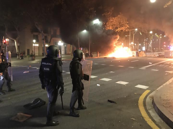 Agents de la Policia Nacional aturats a uns metres d'una barricada en flames a Barcelona el 15 d'octubre del 2019. ACN