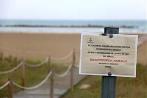 Detall d'un cartell a la platja de la Mota de Sant Pere de Cubelles indicant que el servei de salvament encara no està instaurat. ACN