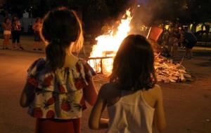 Dues nenes contemplen una foguera a la plaça de la Creu Alta de Sabadell el 23 de juny de 2018. ACN
