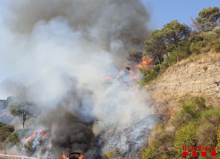 Flames d'un incendi a Capellades el 24 de juliol del 2019, a tocar de la C-15. A la part baixa de la imatge s'aprecia un cotxe incendiat. Bombers