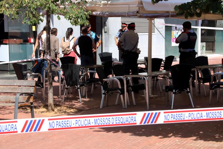 Imatge del precinte i agents de les forces policials a la porta de l'edifici de Terrassa on s'han produït els fets aquest 24 de juliol de 2019. ACN