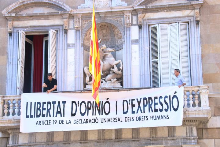 Membres de l'equip del president del Govern, Quim Torra, pengen la nova pancarta a la façana de Palau: 