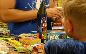 Pla escorç d'un nen observant el mostrador d'una botiga de petards els dies previs a la revetlla de Sant Joan. ACN