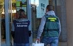 Pla general de dos agents de la Guàrdia Civil i del Servei de Vigilància Duanera a la porta d'una oficina de Correus. Guàrdia Civil
