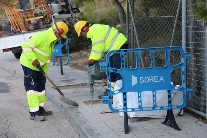 Pla general de dos operaris de la companyia d'aigua de Calafell treballant en el tall de subministrament en un dels habitatges ocupats il·legalment al