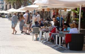 Pla general de la terrassa d'un restaurant de la platja de Sant Sebastià de Sitges plena de gent. ACN
