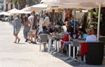 Pla general de la terrassa d'un restaurant de la platja de Sant Sebastià de Sitges plena de gent. ACN