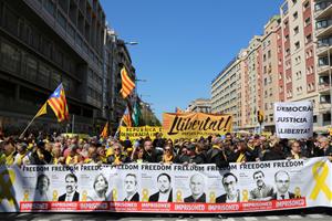 Pla general d'una de les pancartes exhibides a la manifestació de Democràcia i Convivència del 15 d'abril de 2018 amb fotografies dels polítics presos