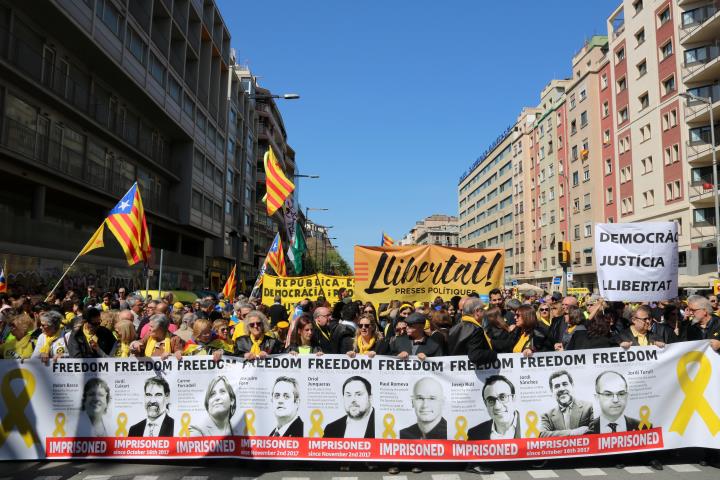 Pla general d'una de les pancartes exhibides a la manifestació de Democràcia i Convivència del 15 d'abril de 2018 amb fotografies dels polítics presos