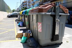 Pla general d'una illa de contenidors d'escombraries de Calafell amb diverses bosses llençades fora