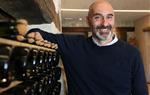 Pla mitjà del president de la Confraria del Cava, Eduard Sanfeliu, recolzat sobre diverses ampolles en una paret. ACN
