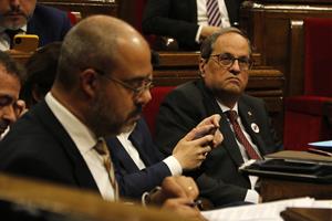 Pla mitjà del president del Govern, Quim Torra, durant el ple del Parlament. En primer pla, desenfocat, el conseller d'Interior Buch. ACN