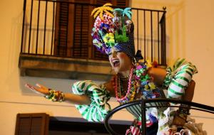 Pla obert contrapicat del Carnestoltes de Sitges ballant dalt la carrossa durant l'Arribo del 28 de febrer del 2019Pla tancat contrapicat de la Reina 