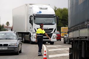 Pla obert d'un agent dels Mossos d'Esquadra aturant un camió a l'N-340, a l'alçada de Roda de Berà (Tarragonès), per on no hauria de circular. ACN