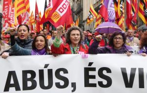 Tres dones representants de CCOO i UGT a la capçalera de la manifestació aguantant la pancarta 'No és abús, és violació' del Primer de Maig. ACN