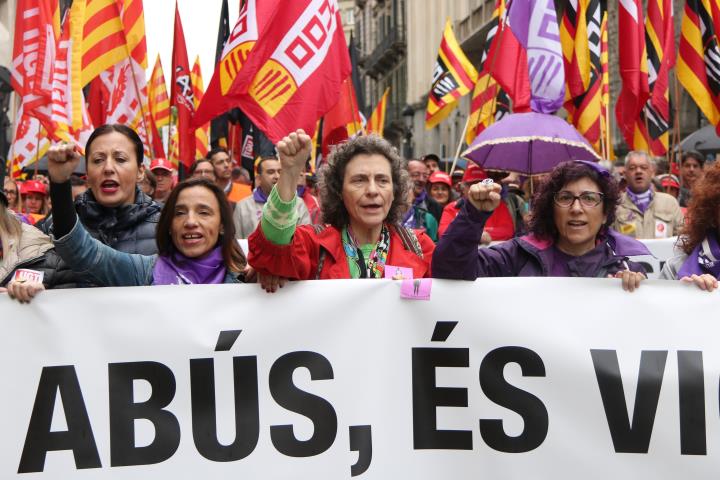 Tres dones representants de CCOO i UGT a la capçalera de la manifestació aguantant la pancarta 'No és abús, és violació' del Primer de Maig. ACN