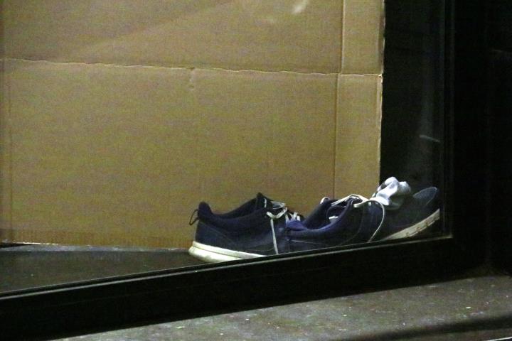 Un parell de vambes i un cartró a l'interior d'un caixer de Sarrià, on dorm una persona sensellar. ACN