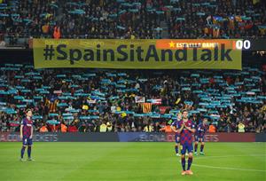 Cartell de Tsunami Democràtic amb el lema 'Spain, sit and talk!' a l'inici del clàssic al Camp Nou darrere dels jugadors, el 18 de desembre del 2019 .