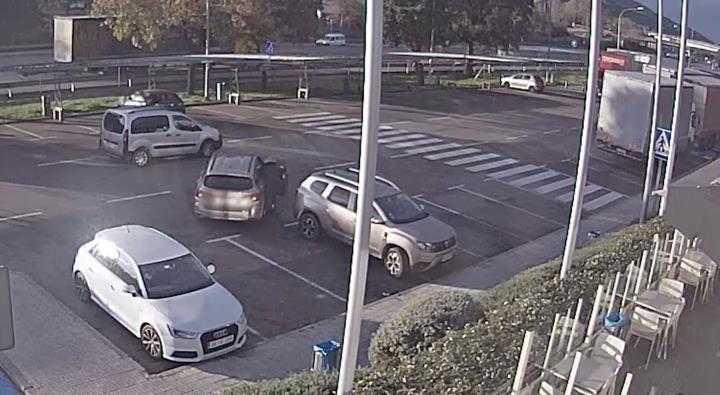 Imatge de càmera de seguretat on es veu una dona intentant pujar a un cotxe que fuig després de robar-li pertinences. Mossos d'Esquadra
