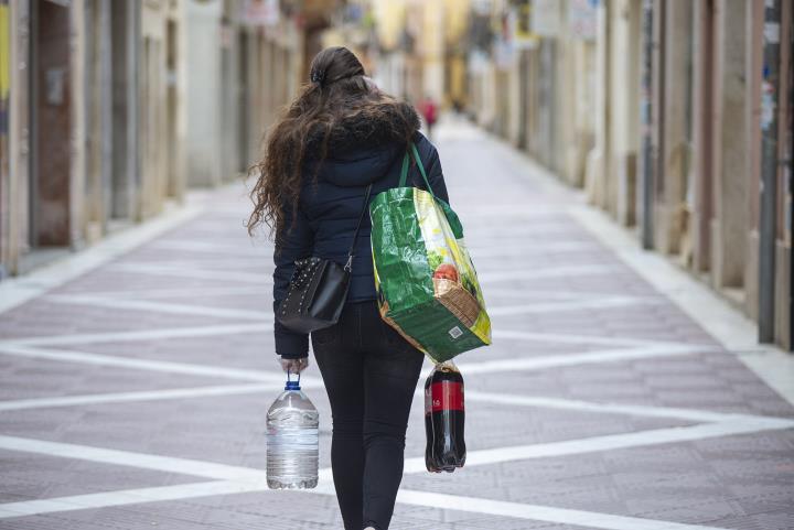 Imatge d'una veïna de Vilanova tornant a casa amb la compra en plena època de confinament. EIX