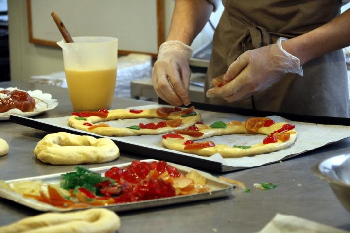 Pla detall d'un pastisser col·locant les fruites al tortell a la pastisseria El Cigne de Manresa. ACN