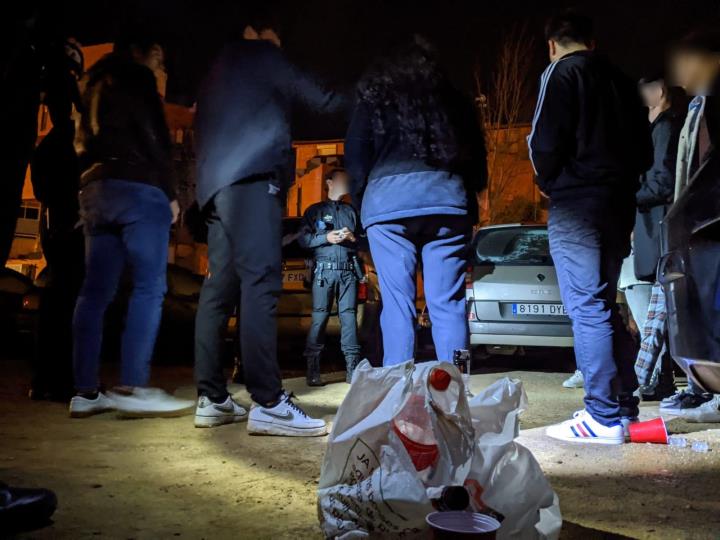 Pla general d'agents de la Guàrdia Urbana de Reus, de nit, denunciant un grup de joves per consumir alcohol a la via pública. Guàrdia Urbana de Reus