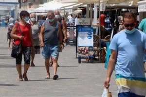 Pla general de persones passejant amb mascaretes per la zona marítima de Calafell Platja, el punt més turístic del municipi. ACN